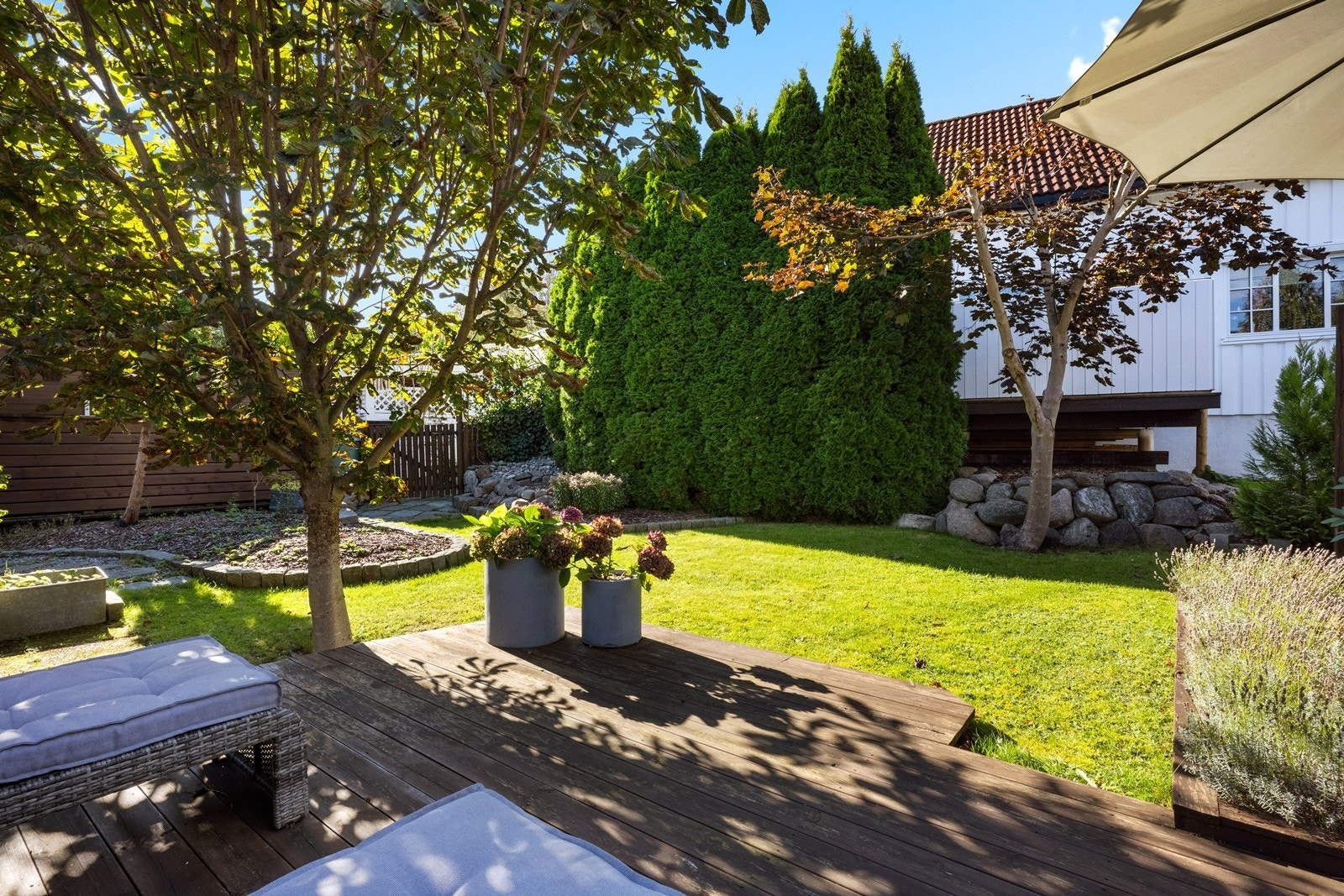 Hagen er opparbeidet med plen, trær og flere markterrasser. Galleribilde