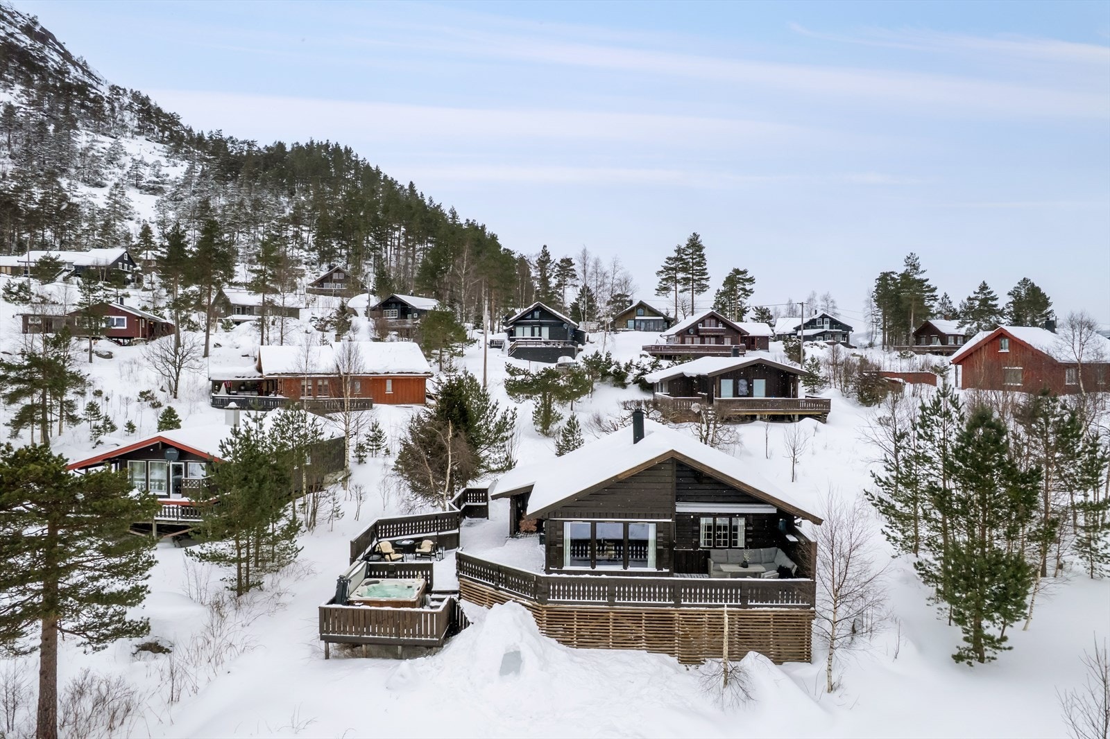 Hytta ligger i midtre del av hyttefeltet, omgitt av et friområde i front. Galleribilde
