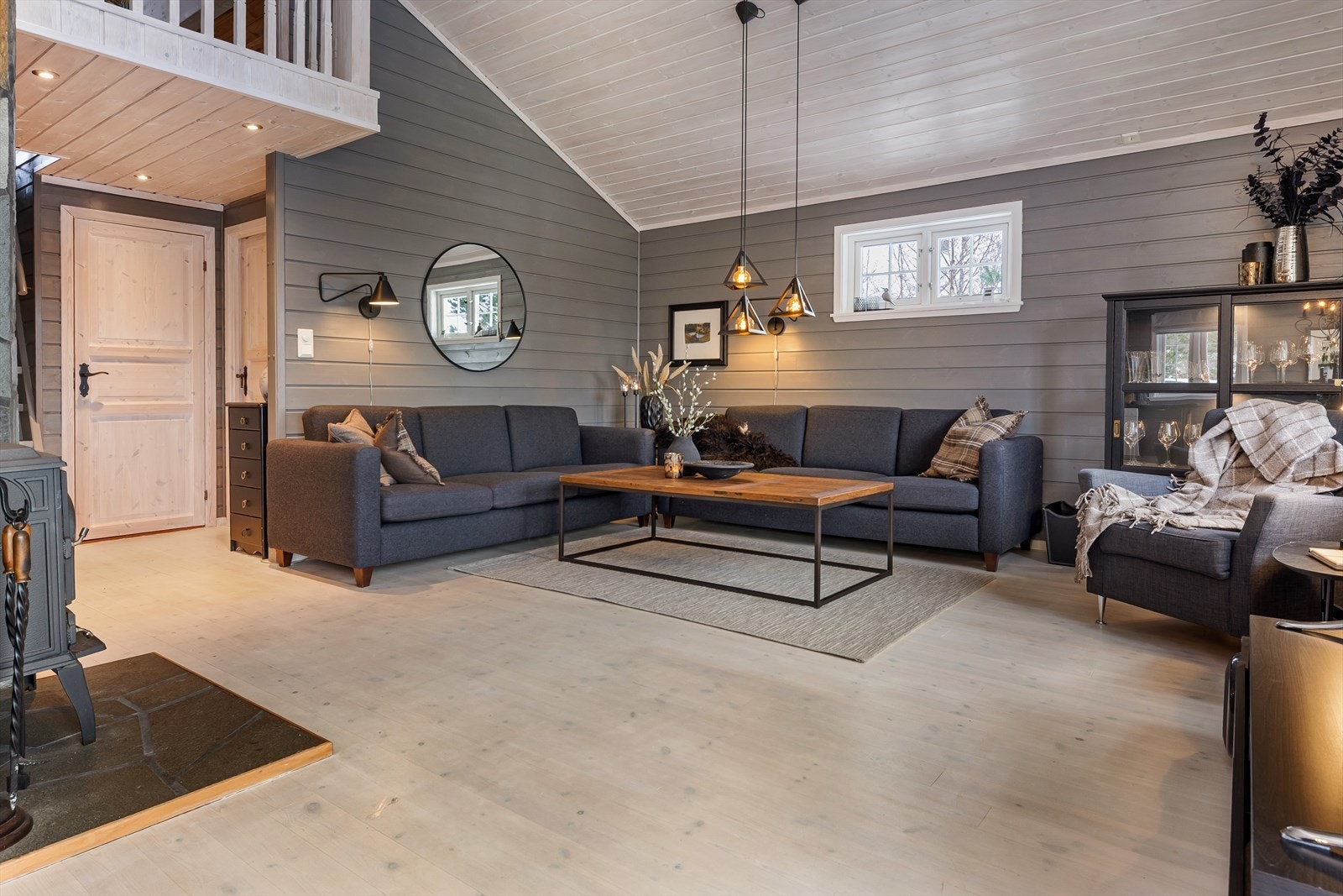 Stuen fremstår som romslig med god takhøyde, en peisovn og varmepumpe som sørger for komfort året rundt Galleribilde