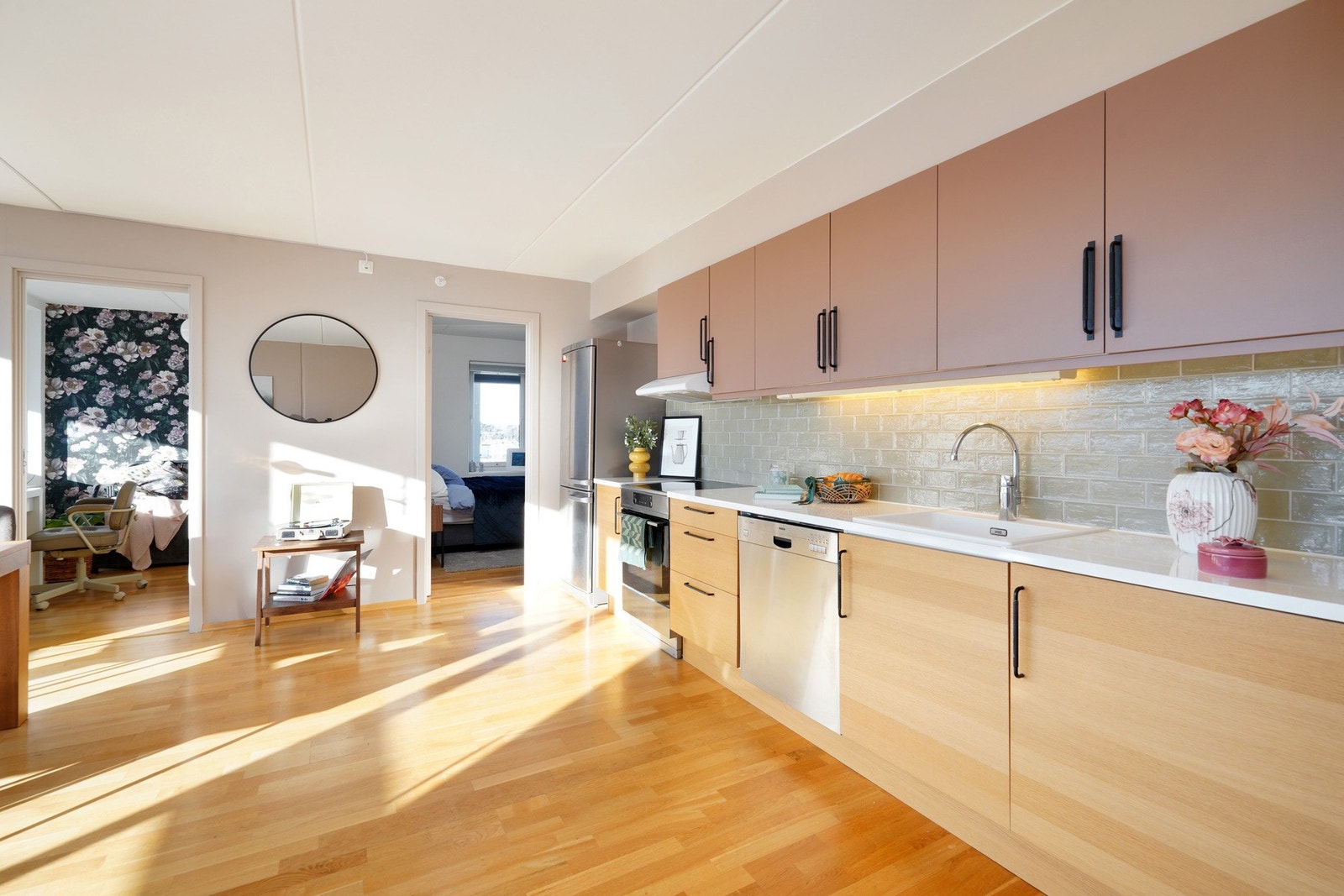 Pent kjøkken med malte overskap og fliser over benkeplate. Galleribilde