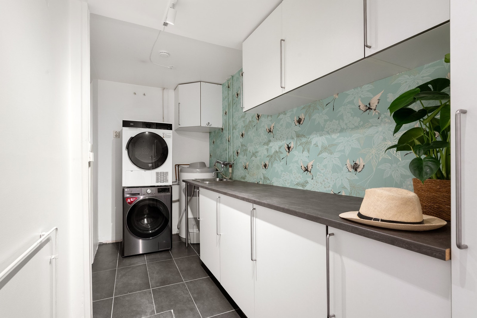 Vaskerommet har innredning med skap og laminat benkeplate Galleribilde