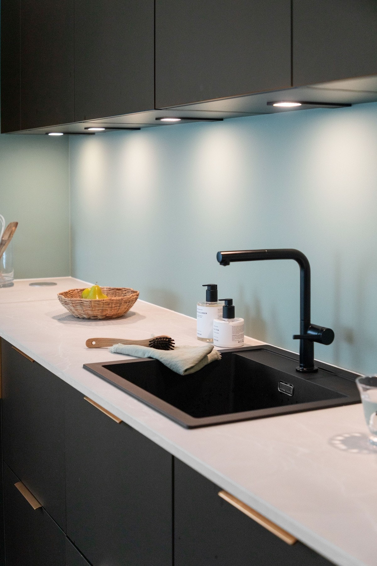 Kjøkkenet har sorte, glatte fronter, laminert benkeplate og sort oppvaskkum i kompositt. Galleribilde