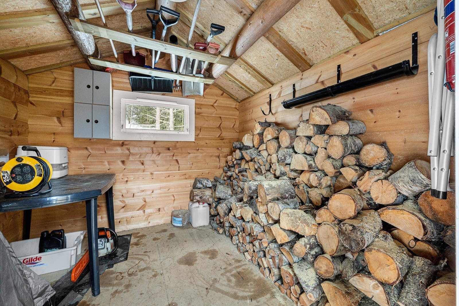 Praktisk frittstående uthus med god lagringsplass til ved, ski og fritidsutstyr. Galleribilde
