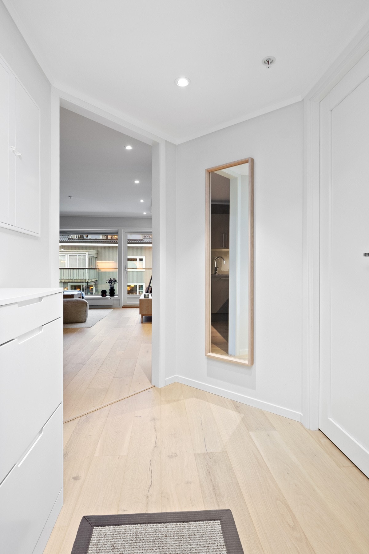 Innbydende gang med downlights i himlingen, hvitmalte veggflater og lyst 1-stavs parkettgulv. Galleribilde