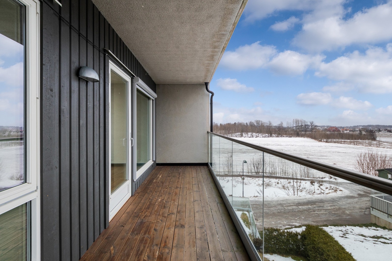 Balkongen har glassrekkverk, belysning og utvendig stikkontakt. Galleribilde