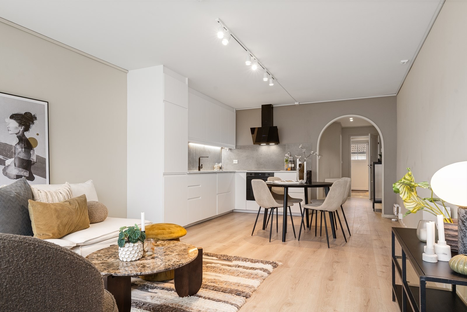 Stue og kjøkken i åpen løsning med plass til sofa og spisebord. Galleribilde