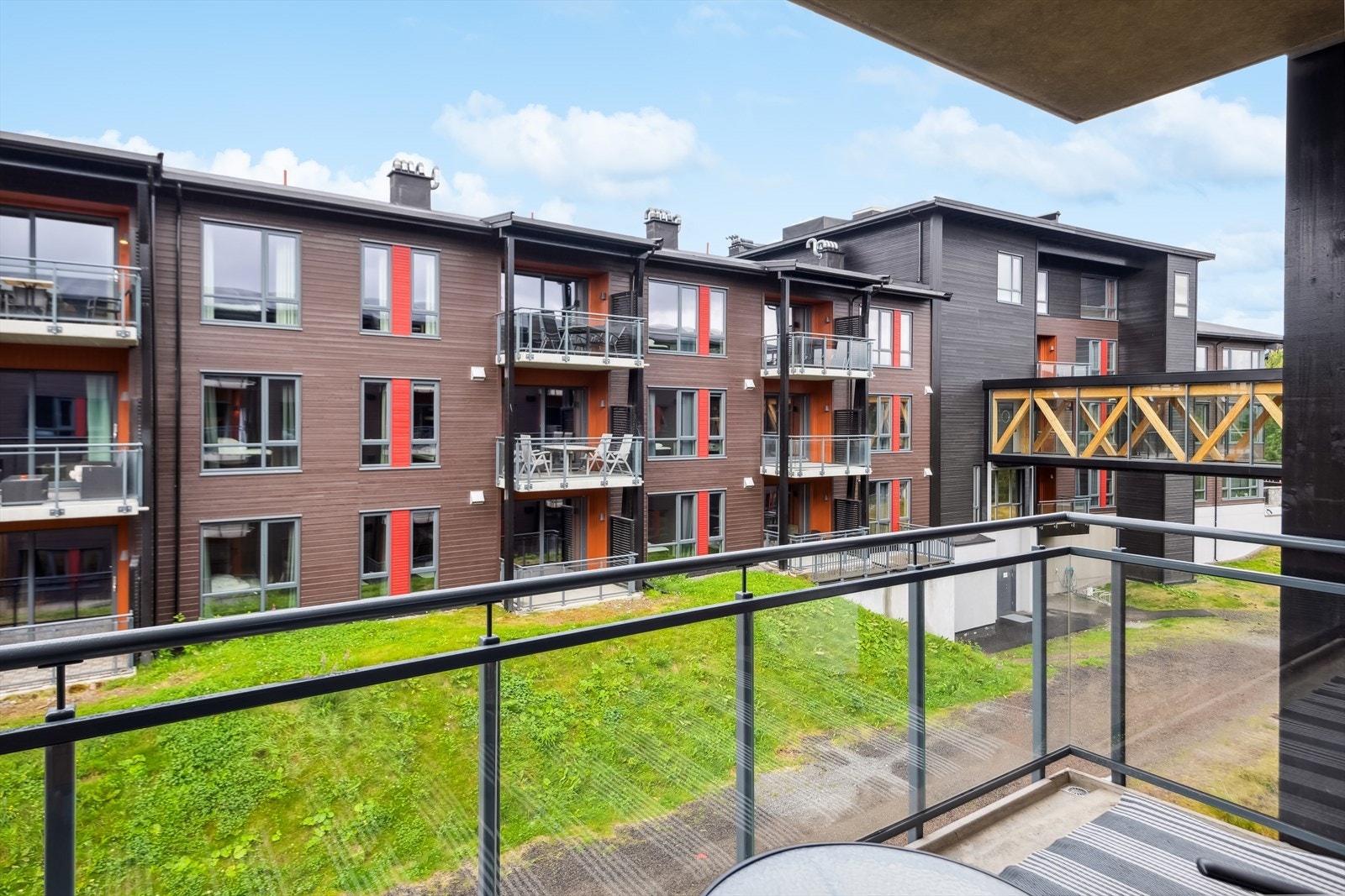 Utsikt fra balkong. Parkeringskjeller i nabobygget, med heis og adkomst via gangbru mellom byggene. Galleribilde