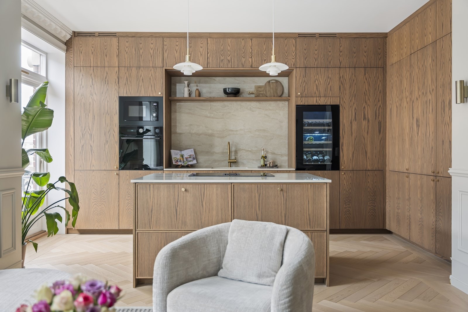 Kjøkkenet har en moderne innredning med glatte, finerte fronter fra Fossum Møbelsnekkeri AS, benkeplate i stein (dekton) og matchende backsplash. Kjøkkenfronter er spesiallaget av møbelsnekker Fossum Møbelsnekkeri AS. Galleribilde