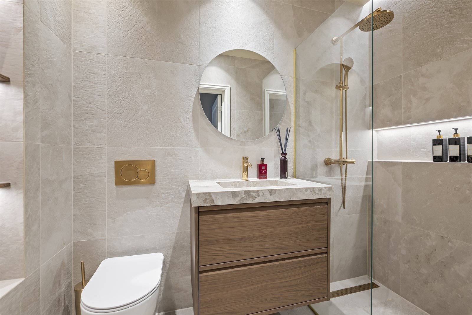 Innredningen består av en skuffeseksjon med en plassbygget, flislagt servant, speil med integrert lys og et vegghengt toalett. Galleribilde