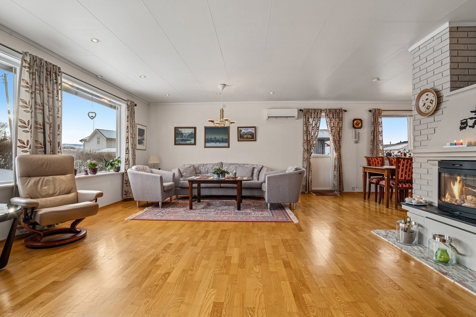 Stuen er utført i lyse fargetoner og downlights i himlingen - Det er flere store vindusflater som slipper inn mye lys og skaper en luftig atmosfære (2 nye vindusglass i stuen 2022) Galleribilde