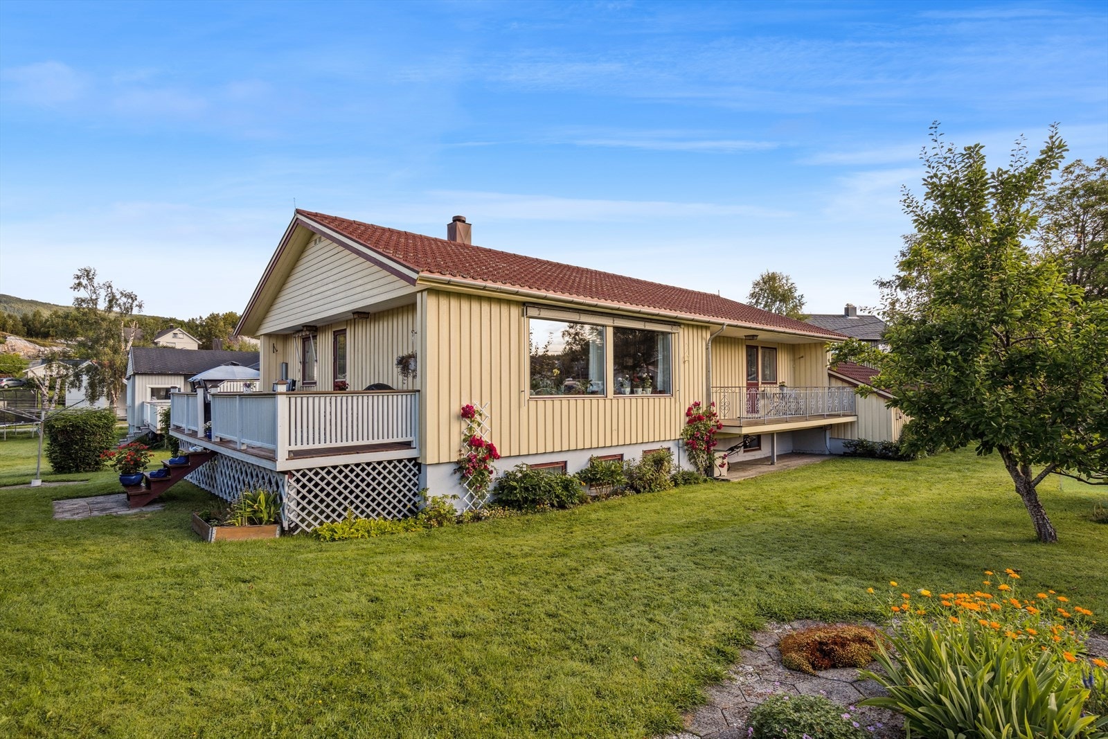 Hagen er svært pent opparbeidet med plen, blomster, busker og trær Galleribilde