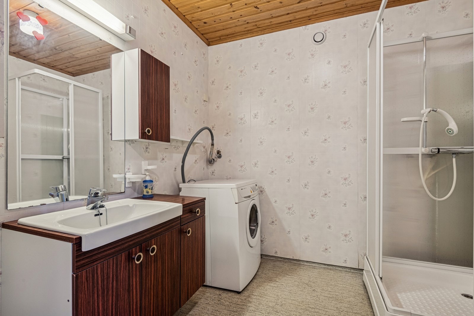 Bad/vaskerommet i hybelen har gulvbelegg med varmekabler og er innredet med dusjkabinett og opplegg til vaskemaskin. Galleribilde