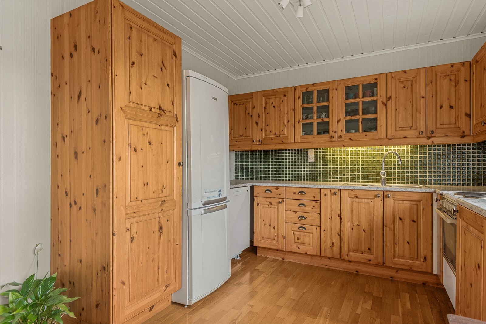 Kjøkkenet har profilerte fronter, benkeplate av laminat fliser mellom over- og underskap. Galleribilde