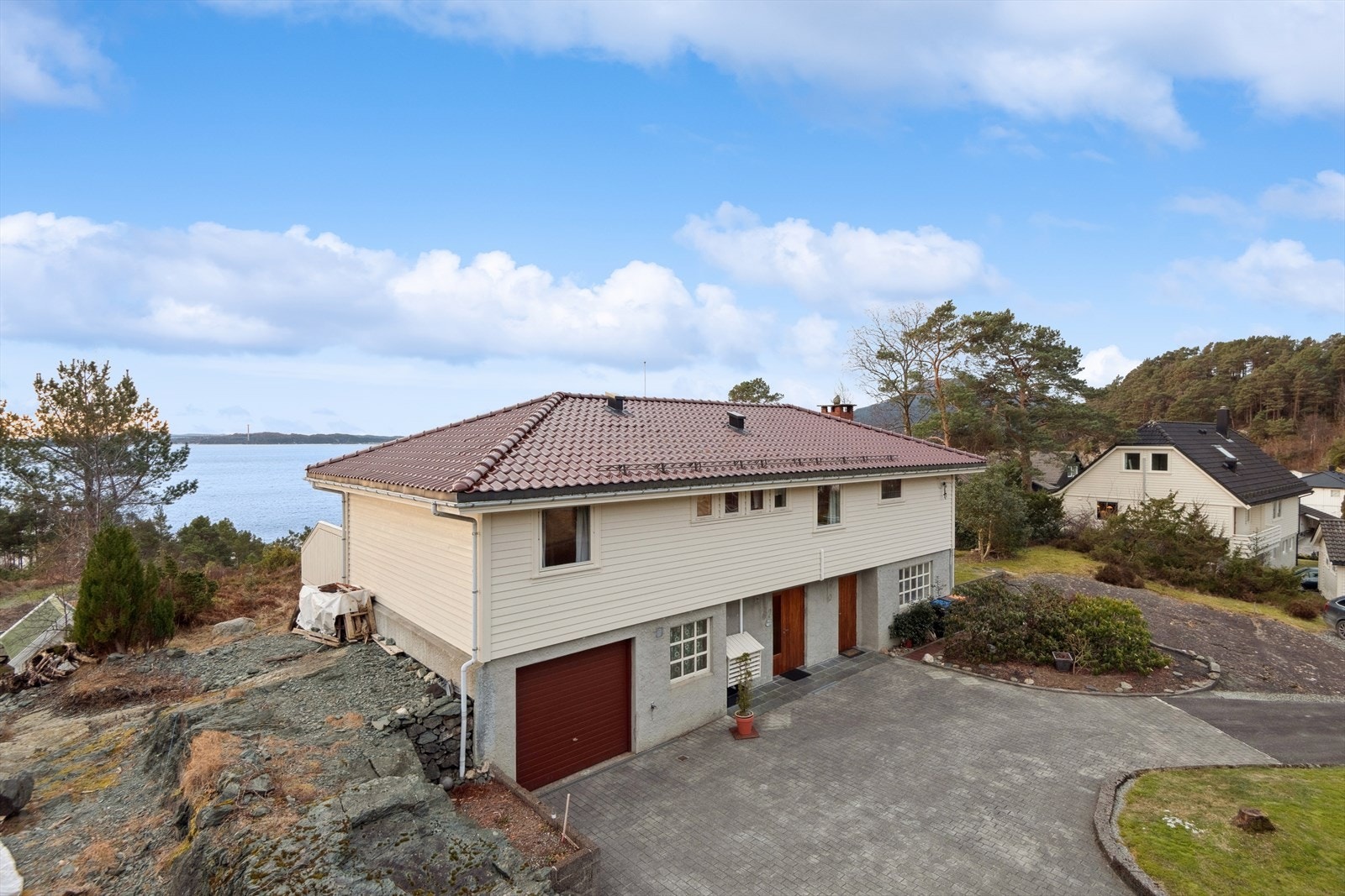 Det er tilgang til garasje fra forsiden av huset, og eiendommen har en romslig oppkjørsel med plass til flere biler. Galleribilde