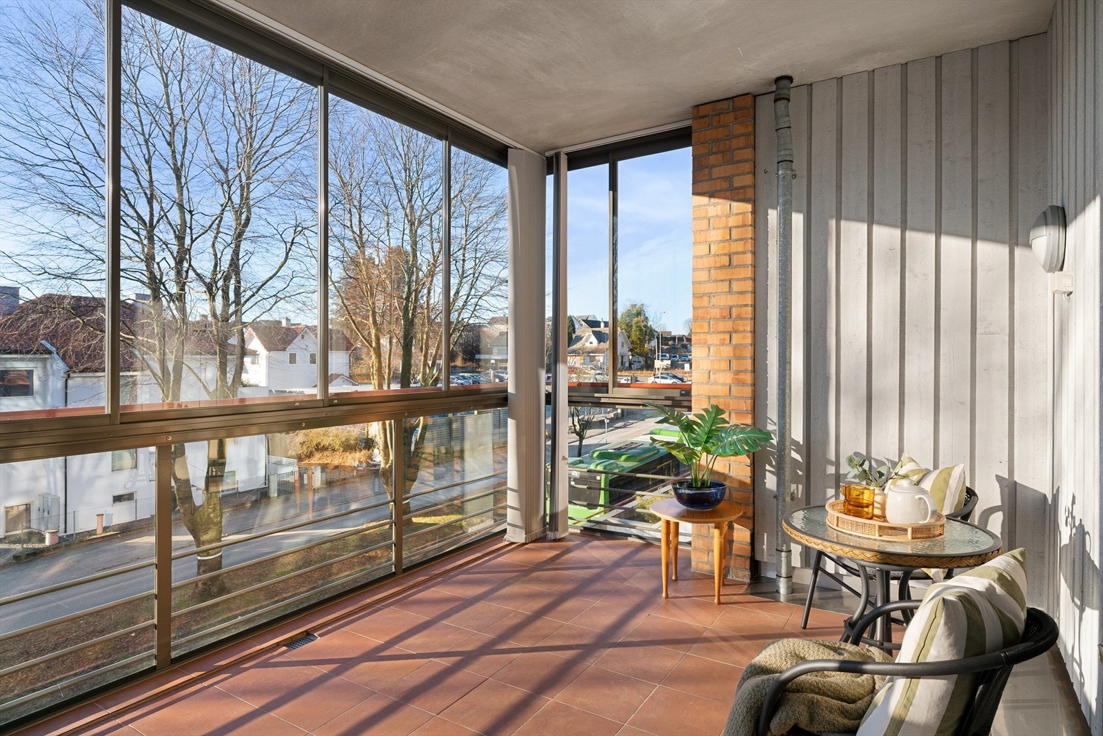 Den innglassede balkongen har fliser på gulv og fungerer som et ekstra oppholdsrom store deler av året. Galleribilde