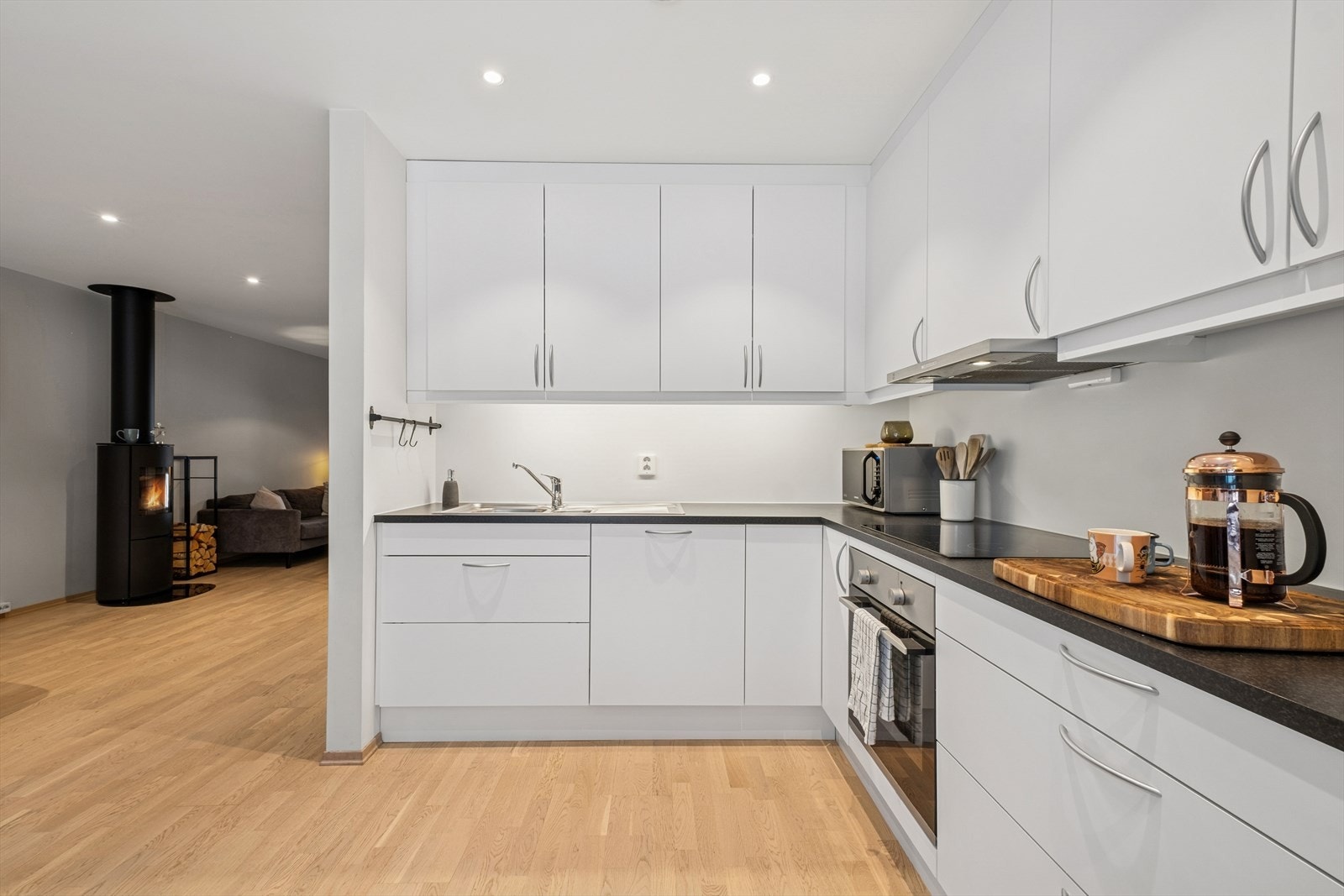 Kjøkkenet ligger i åpen løsning mot stuen som fremstår moderne og innbydende, med god benkeplass, samt rikelig med skapplass. Galleribilde