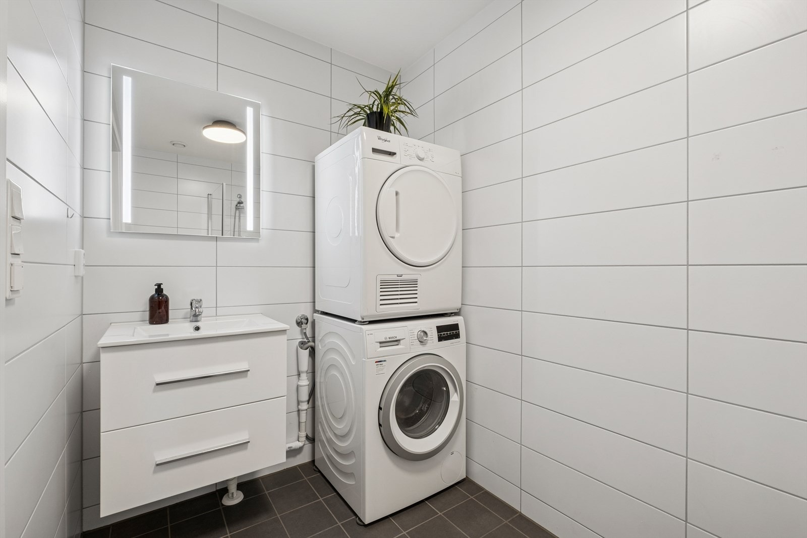 Baderommet i 1. etasje er flislagt med behagelig gulvvarme. Her er det opplegg for vaskemaskin. Galleribilde