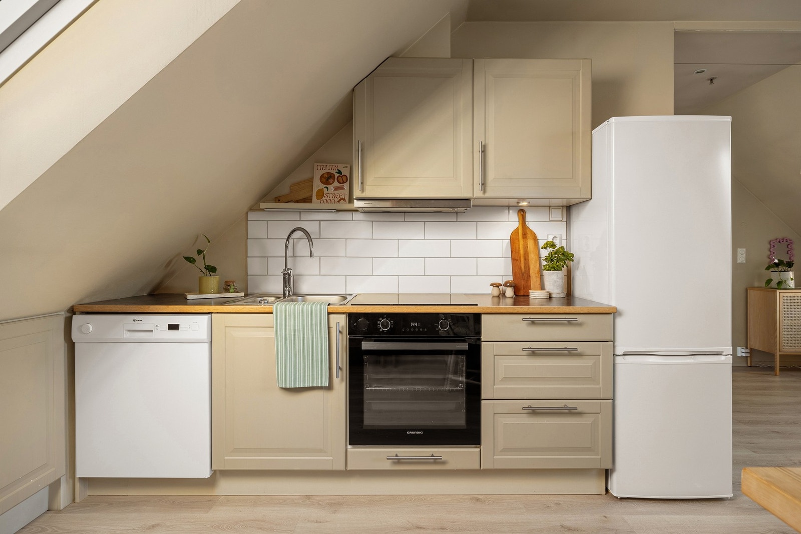 Kjøkkenet har profilerte fronter, laminat benkeplate med nedfelt stålvask og fliser over benk. Galleribilde