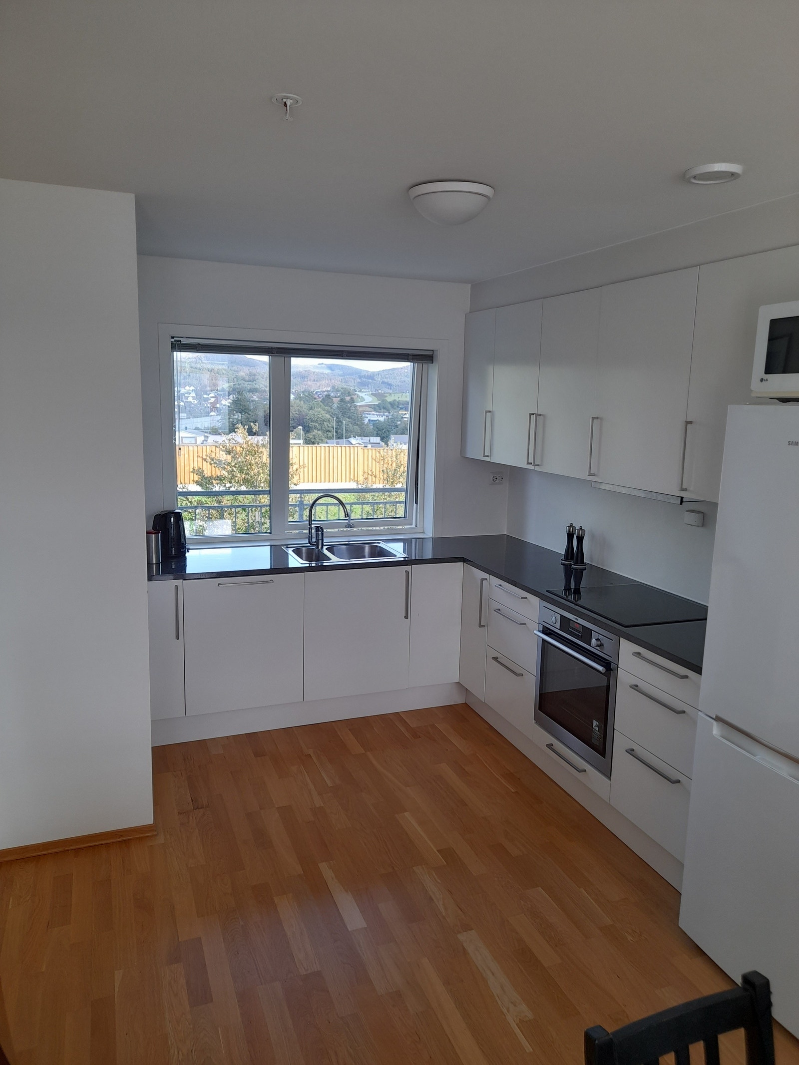 Fullt utstyrt kjøkken med integrerte hvitevarer og kombiskap. Galleribilde