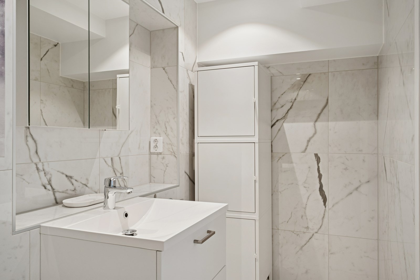 Det er opplegg til vaskemaskin og plass til ekstra oppbevaringsmøblement i kroken. Galleribilde