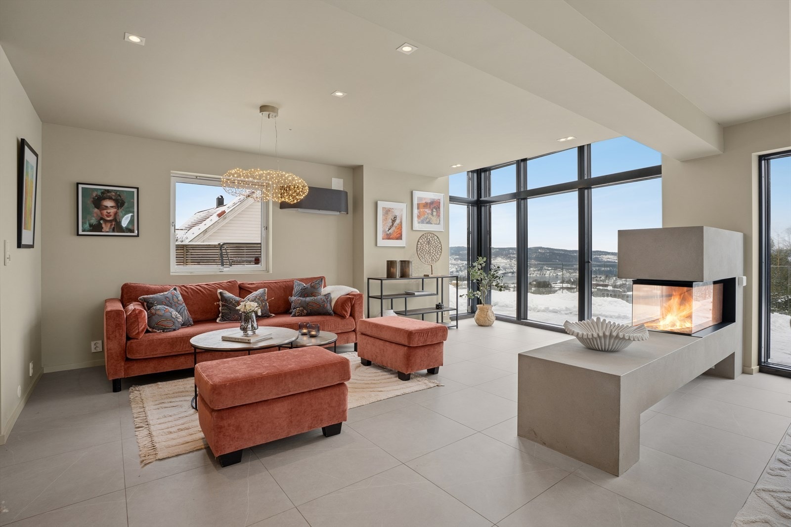 Gulvet er belagt med elegante fliser, og de duse veggfargene kombinert med store vindusflater og terrassedør gir rikelig dagslys og en behagelig atmosfære Galleribilde