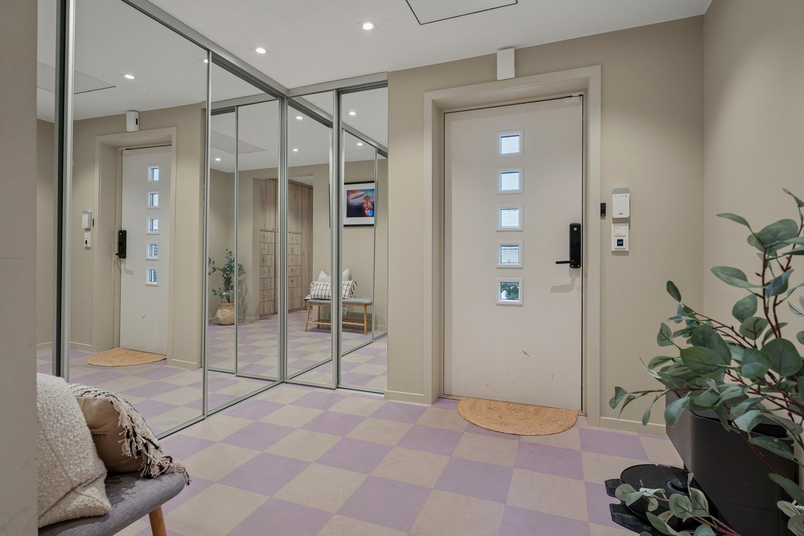 Boligen ønsker deg velkommen med en stilren hvit ytterdør med glassfelt som slipper inn et mykt, naturlig lys og skaper en innbydende atmosfære allerede ved inngangen Galleribilde