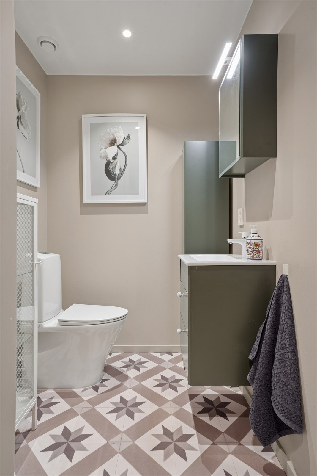 Toalettrommet fremstår moderne og gjennomført i delikate farger og downlights i himlingen Galleribilde