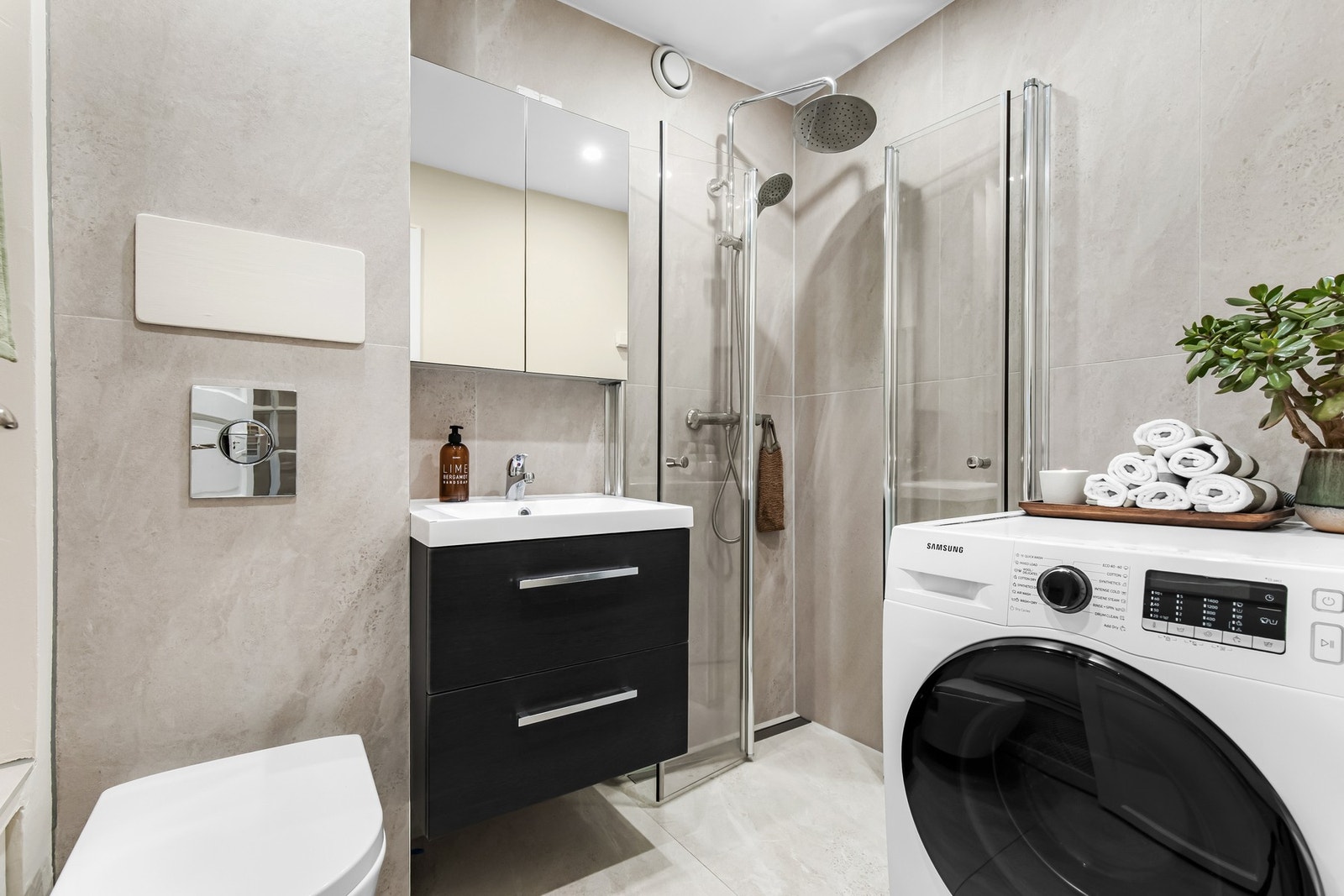 Utstyrt med servantskap og speilskap, veggmontert klosett samt dusjsone med glassdører og termostatstyrt blandebatteri. Opplegg for vaskemaskin. Galleribilde