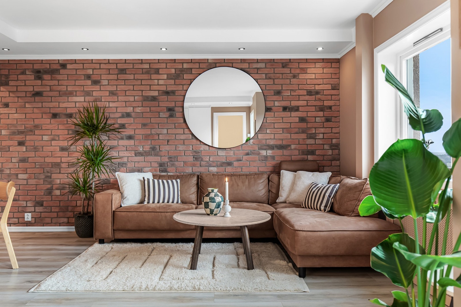 Overflatene i stuen består av laminatgulv og glatte, malte vegger, med enkelte flater i teglstein som tilfører rommet karakter. Galleribilde