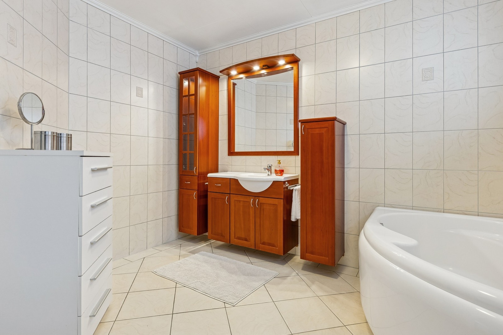 1. etasje - Pent og romslig bad med fliser på vegger og gulv med varmekabler, samt praktisk innredning med god oppbevaringsplass Galleribilde