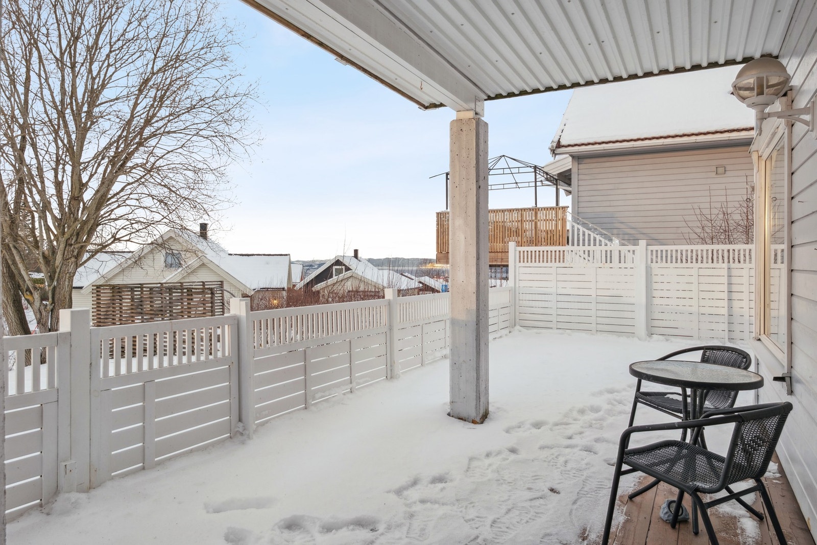 Delvis takoverbygget veranda med god plass til hagemøbler. Galleribilde