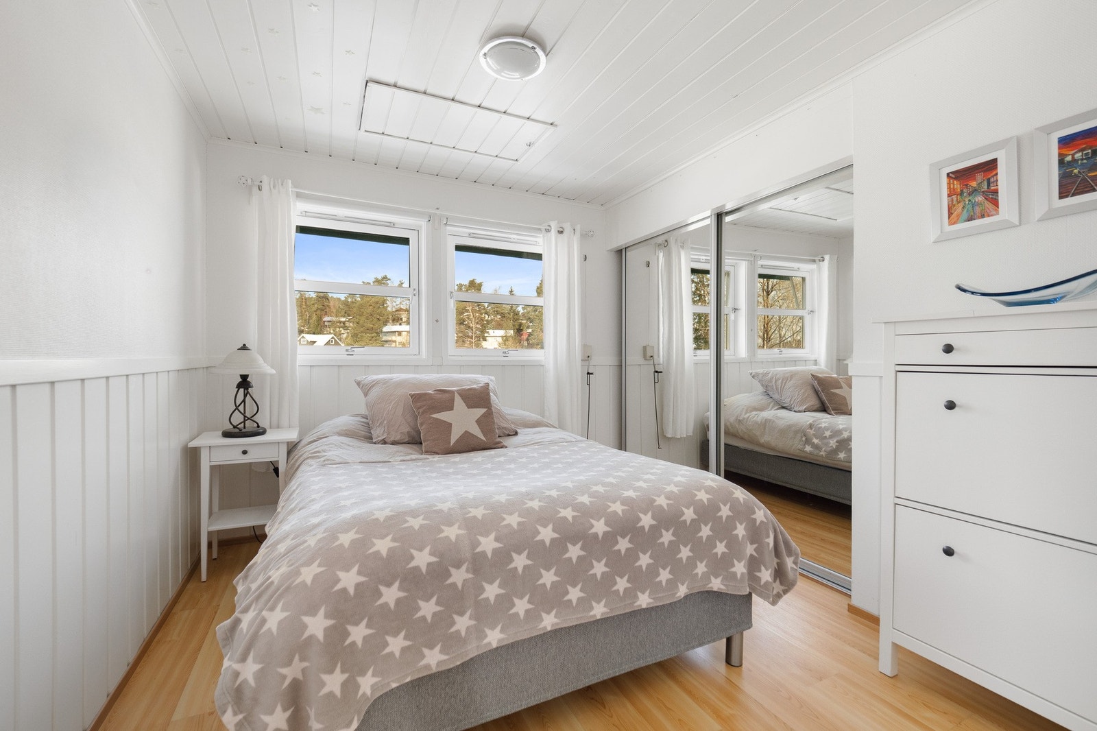 Lyst soverom med store vinduer og speilskyvedørsgarderobe som gir en romslig følelse. Galleribilde