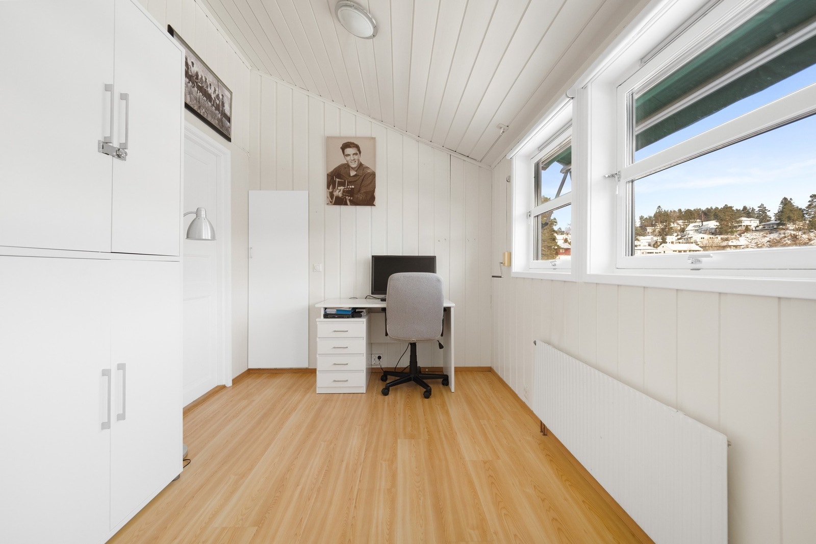 Soverom med lyse vegger, stort vindu og plass til skrivebord. Galleribilde