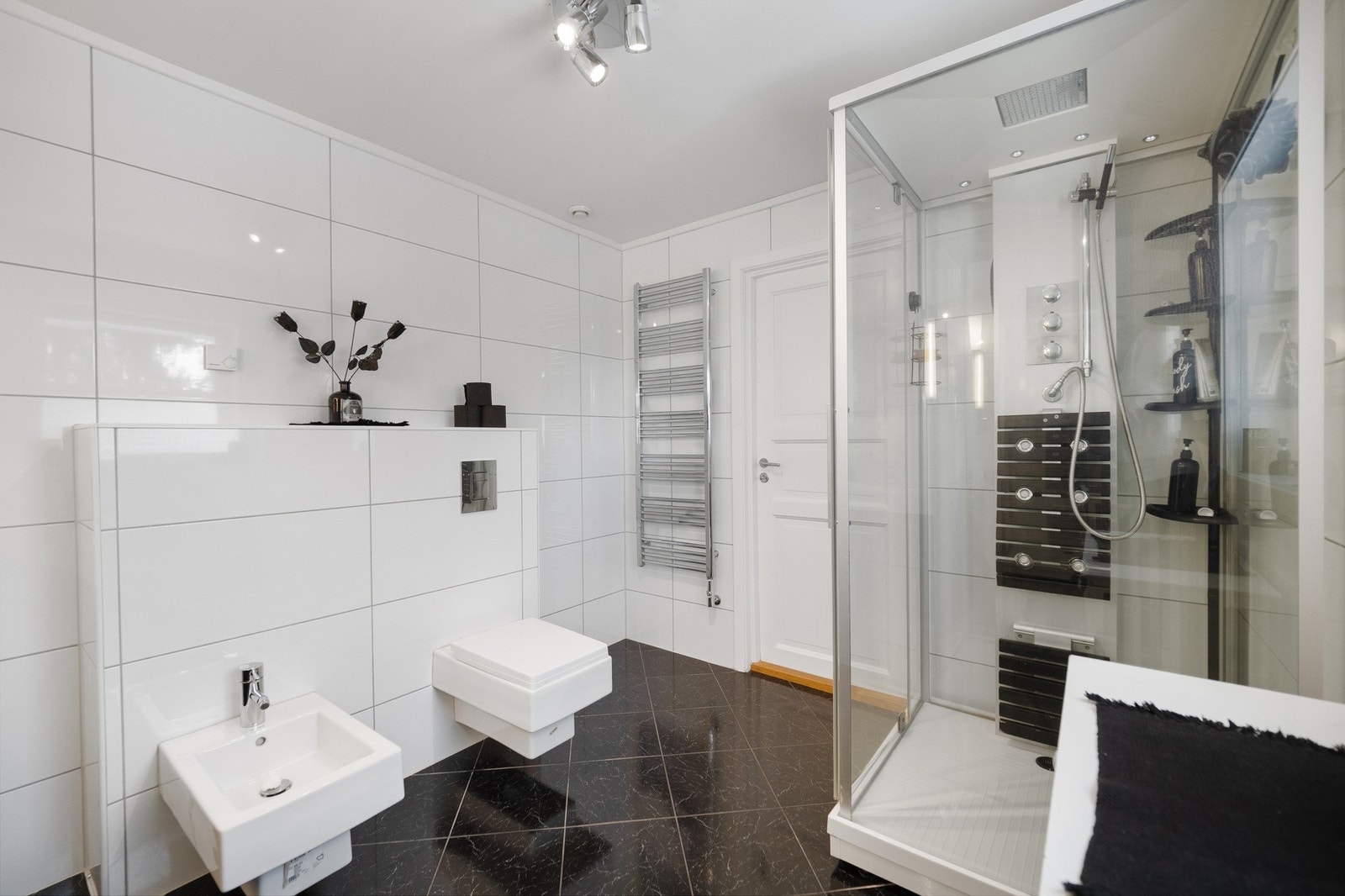 Veggene er flislagt med store, moderne hvite fliser. Galleribilde