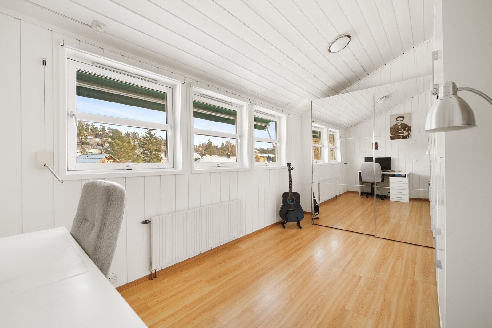 Lyst rom med speilskap, og laminatgulv. hele tre vinduer i rekke er en stilig detalj. Galleribilde