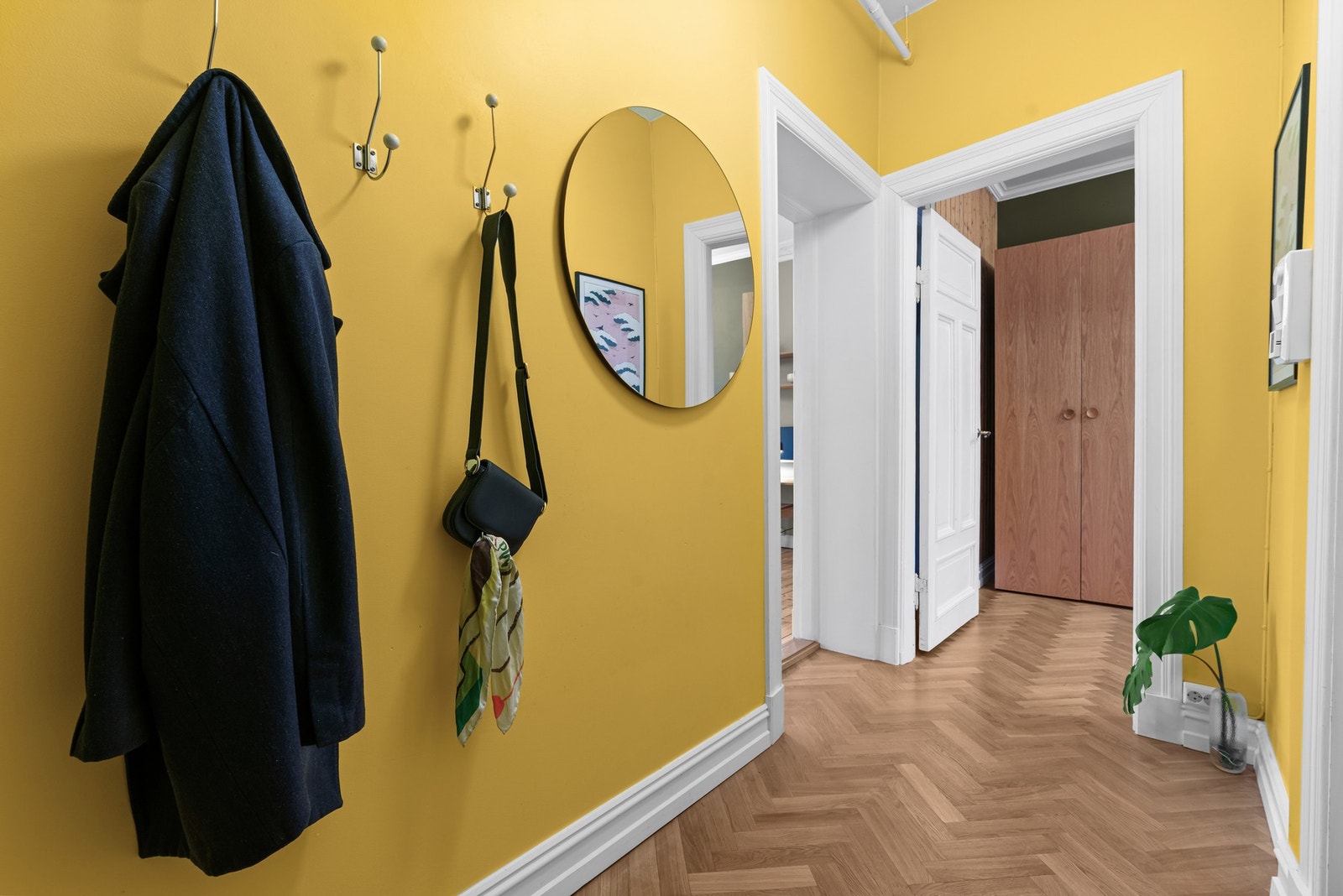 Gangen har lekker fiskebensparkett fra 2017, og veggene har glattmalte flater malt i en stilig gultone (nymalt i 2023) Galleribilde