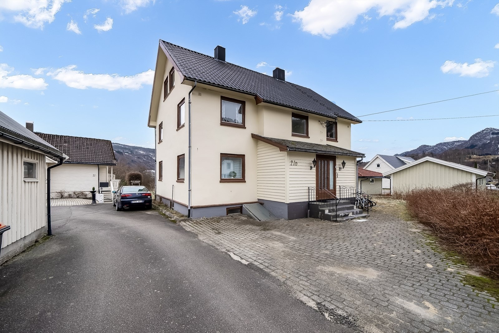 Asfaltert innkjørsel og belegningsstein i gårdsrommet. Galleribilde