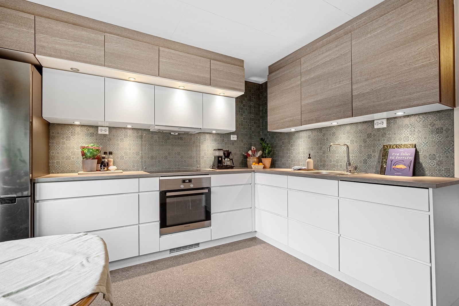 Pen kjøkkeninnredning fra Kvik, med integrerte hvitevarer og moderne utseende Galleribilde