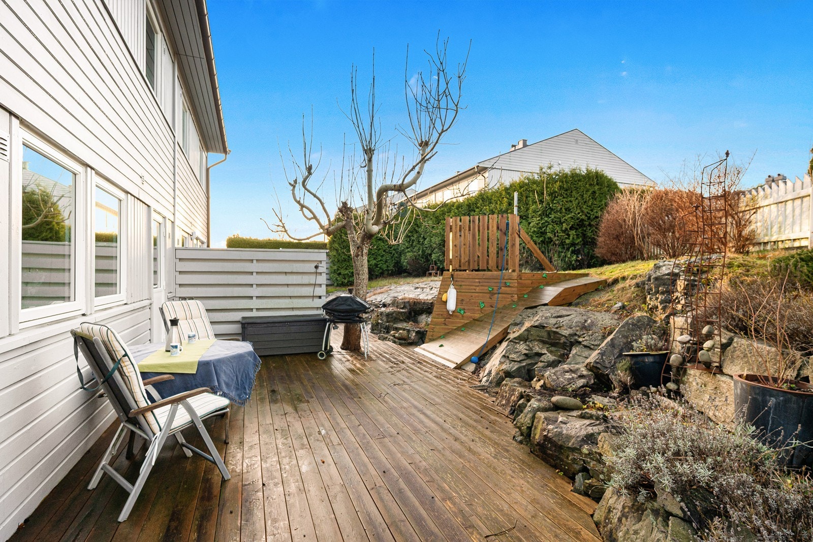 Mot vest er det opparbeidet en hyggelig uteplass med klatrevegg og bærbusker som nyter godt av de gode solforholdene! Galleribilde