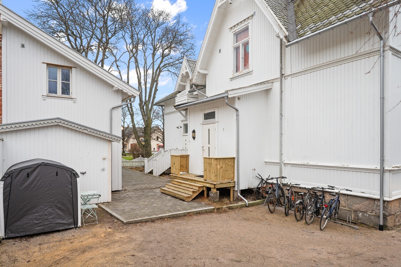 Tomten som er fellesareal er delvis inngjerdet og har en gruslagt gårdsplass Galleribilde