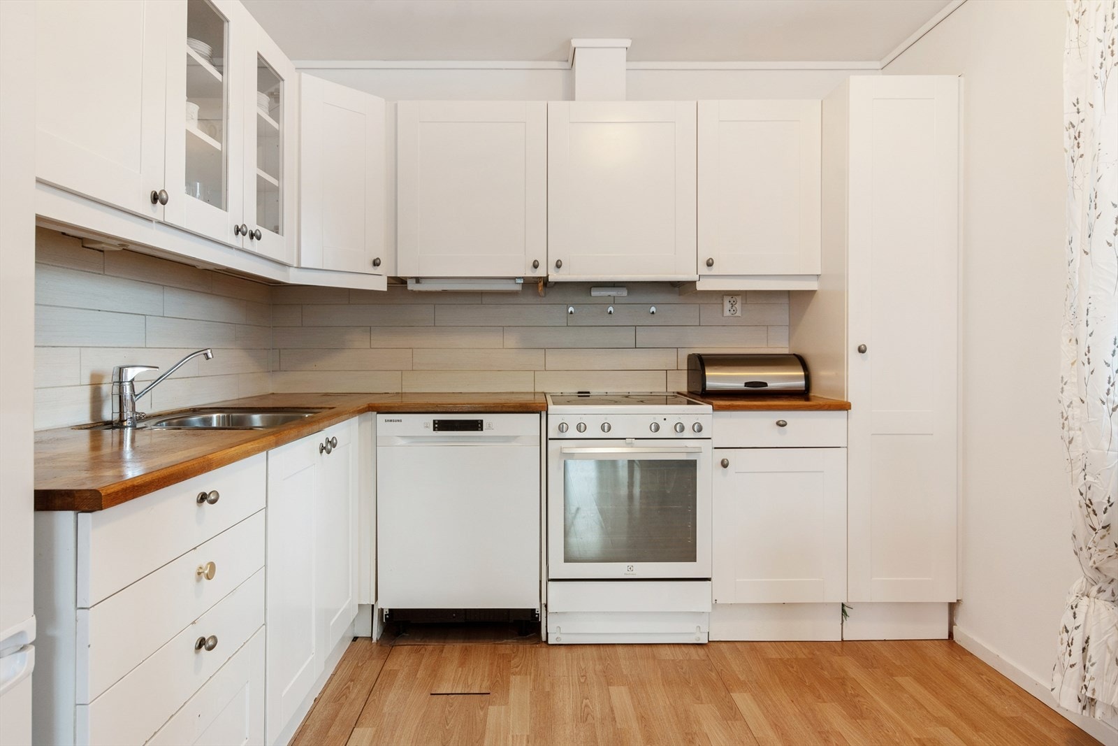 Kjøkkenet har en innredning med profilerte fronter og benkeplate i heltre. Galleribilde