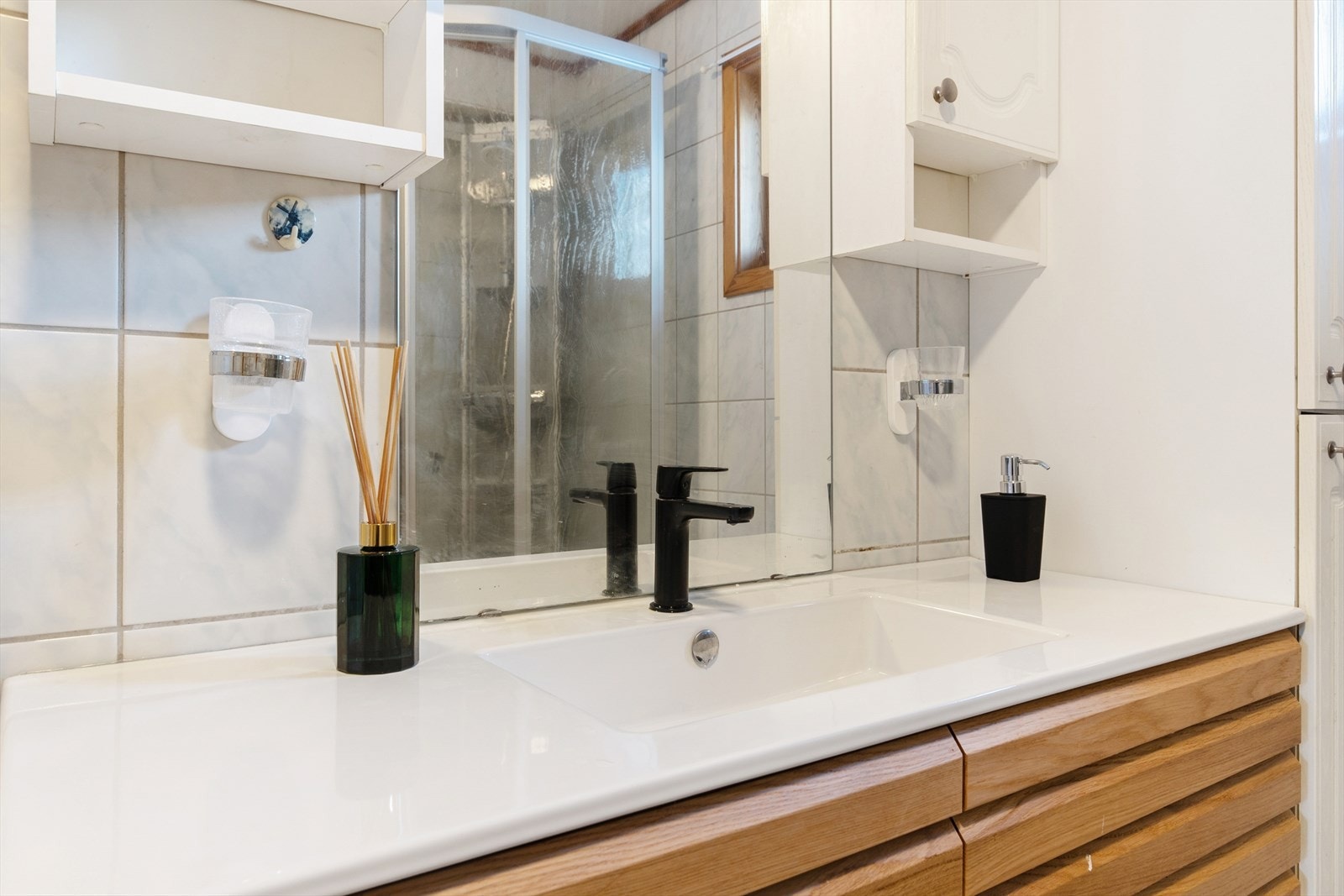 Rommet er utstyrt med en innredning med nedfelt servant, toalett og dusjkabinett. Galleribilde