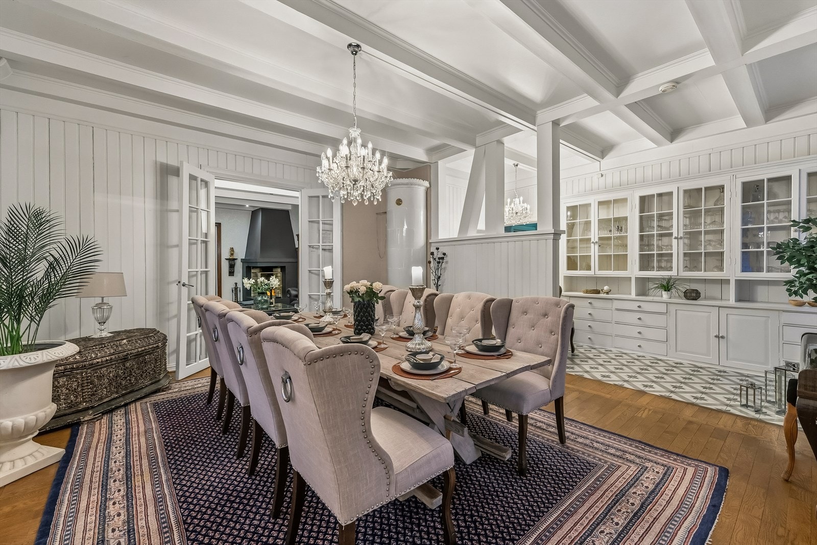 Storslått spisestue med takbjelker, panelerte vegger og vakker kakkelovn. Galleribilde