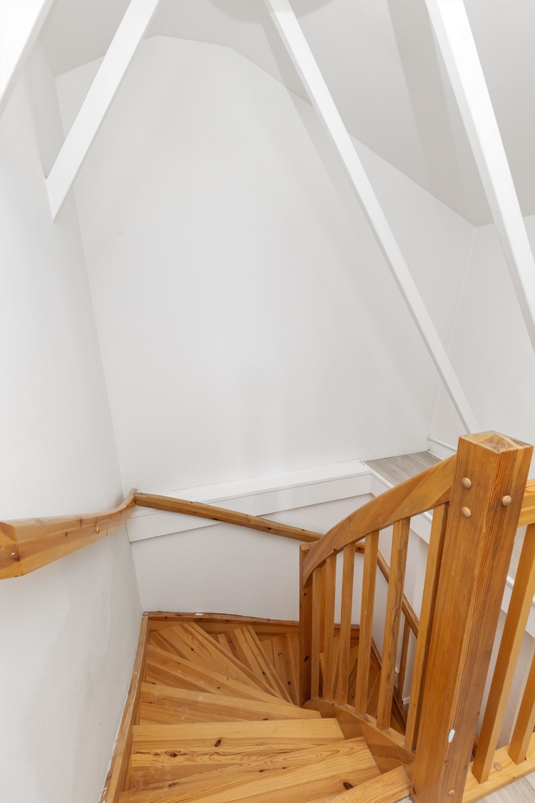 En solid tretrapp leder opp til leilighetens innredede loft. Galleribilde