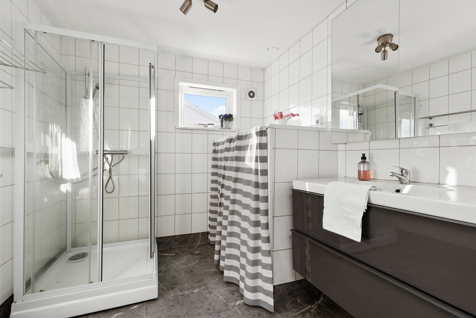 Badet ble oppgradert i 2011 og har gulvbelegg samt flislagte vegger. Rommet er utstyrt med dusjkabinett og servantinnredning med skuffer, samt varmtvannsbereder og opplegg for vaskemaskin. Galleribilde