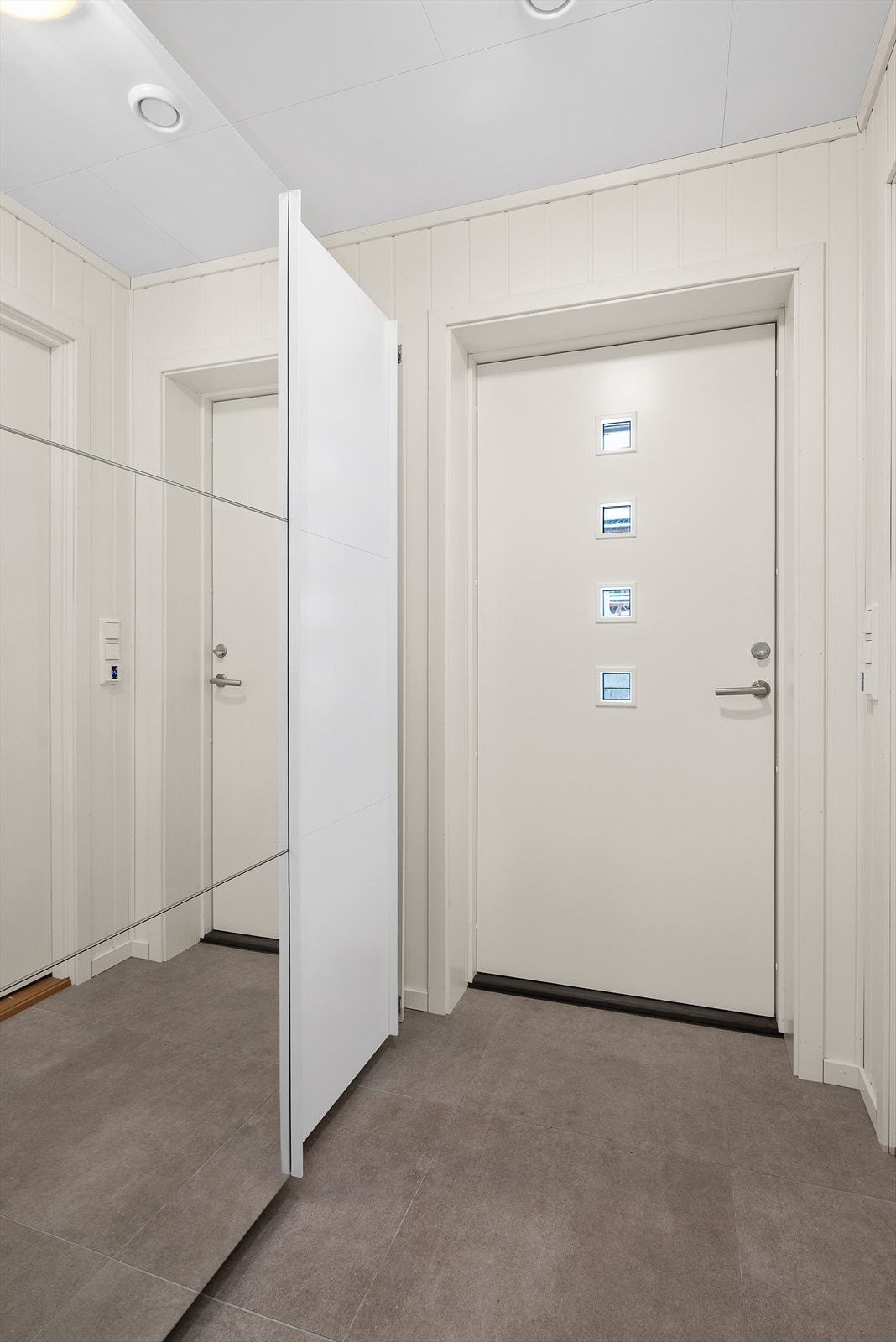 Du blir ønsket velkommen inn i boligen, av en hyggelig entré med skyvedørsgarderobe og gulvvarme. Galleribilde