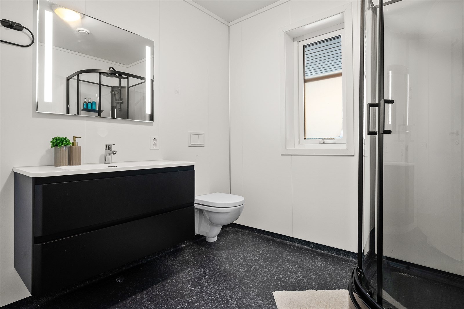 Badet er på ca. 6 kvm, og har hvite våtromsplater på veggene og koksgrått belegg på gulv med gulvvarme. Galleribilde