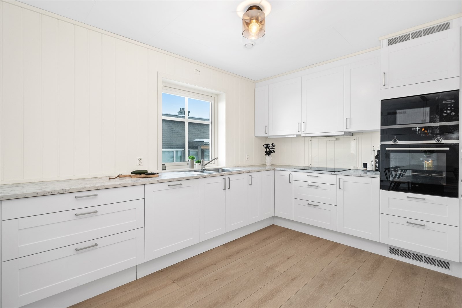 Kjøkkenet har et moderne og stilfullt design med god skap- og benkeplass. Galleribilde