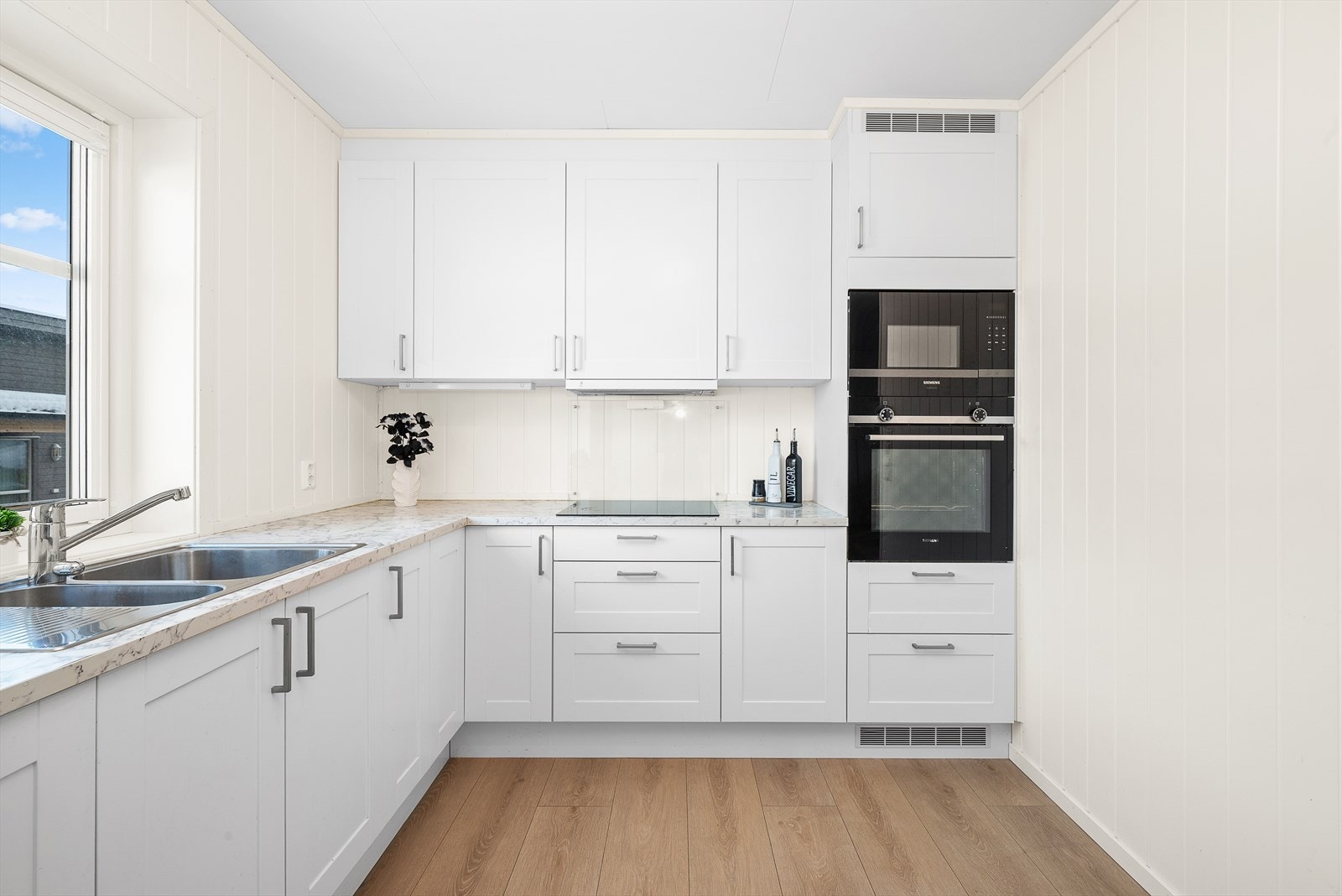 Den oppgraderte innredningen er fra Norema, og har hvite profilerte fronter, takhøye skap og grå laminat-benkeplate. Galleribilde