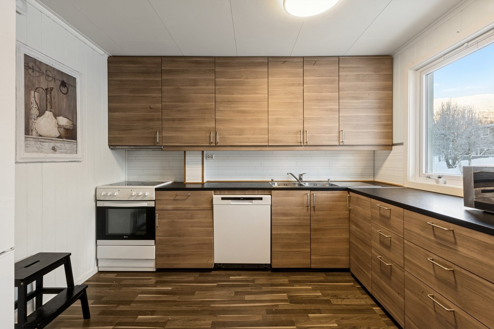 Kjøkkeninnredning er utført med laminerte skrog, laminerte slette fronter, laminert benkeplate med nedfelt oppvaskkum i stål og ett-greps blandebatteri. Galleribilde